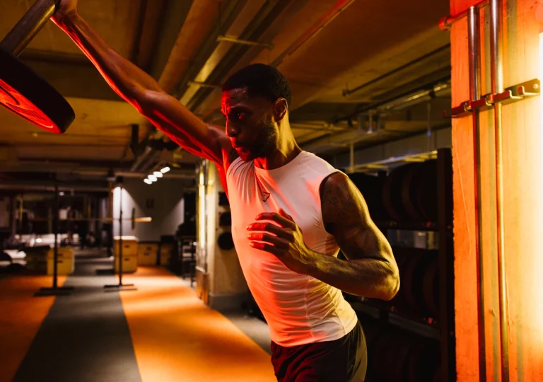 Gymbox Strength, athlete uses landmine press on gym floor
