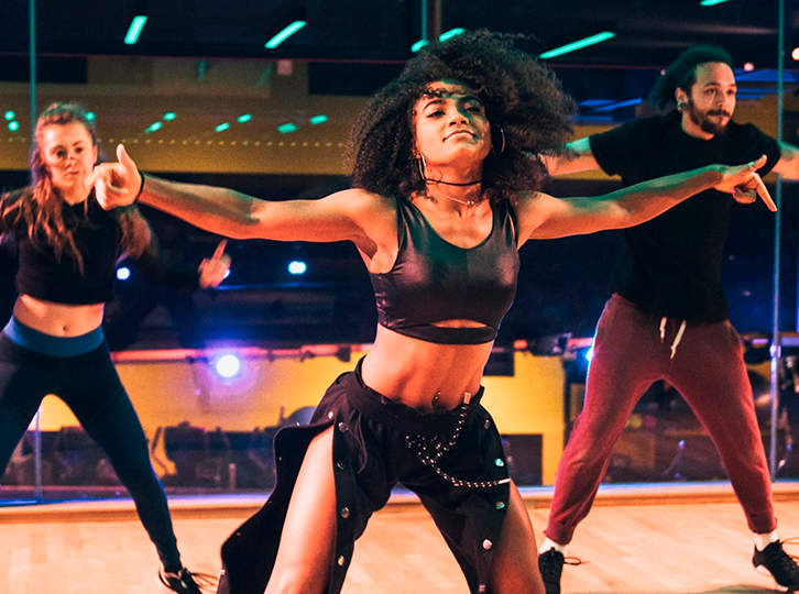 3 people are dancing together withing Gymbox Covent Garden mezzanine studio.
